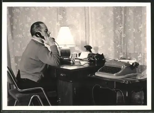 Fotografie Mann mit Telefon im Arbeitszimmer, Schreibmaschine