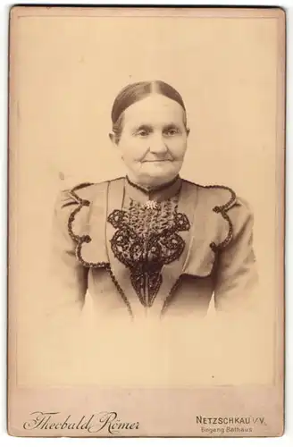 Fotografie Theobald Römer, Netzschkau i. V., Portrait betagte Dame mit zurückgebundenem Haar und Stickerei an der Bluse