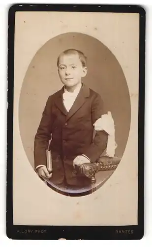 Fotografie C. Peigne, Nantes, Portrait eines Jungen im Anzug und mit Buch in der Hand