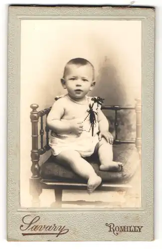 Fotografie Savary, Romilly, niedliches Baby auf einem Stuhl sitzend