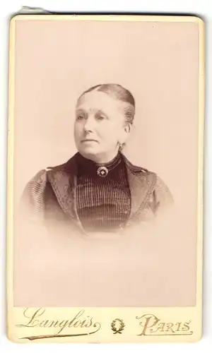 Fotografie Langlois, Paris, Portrait hübsche Dame mit zurückgebundenem Haar und Brosche am Kragen