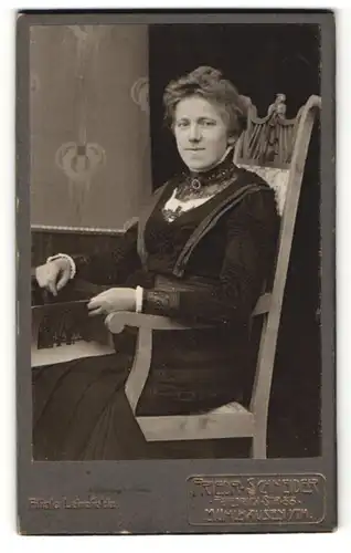 Fotografie Friedr. Schneider, Mühlhausen i. Th., charmant lächelnde Dame mit Zeitschrift im Stuhl sitzend