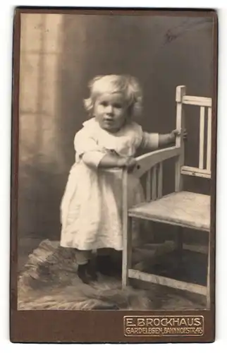 Fotografie E. Brockhaus, Gardelegen, niedliches blondes Kleinkind im weissen Kleidchen