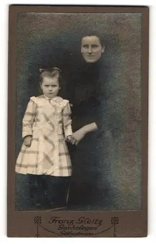 Fotografie Franz Gleitz, Gardelegen, dunkelhaarige Dame mit niedlichen kleinen Mädchen im karierten Kleid