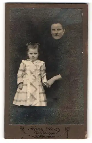 Fotografie Franz Gleitz, Gardelegen, hübsche dunkelhaarige Mutter mit kleinem Mädchen im karierten Kleid
