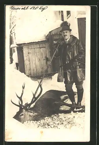 AK stolzer Jäger mit erlegtem Hirsch im Winter