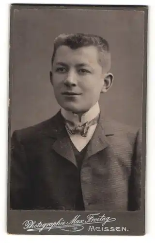Fotografie Max Freitag, Meissen, Portrait charmant lächelnder junger Mann mit Fliege im Anzug