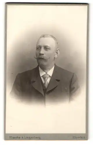 Fotografie Flasche & Lingenberg, Elberfeld, Portrait Herr mit Schnauzbart im Anzug mit Krawatte