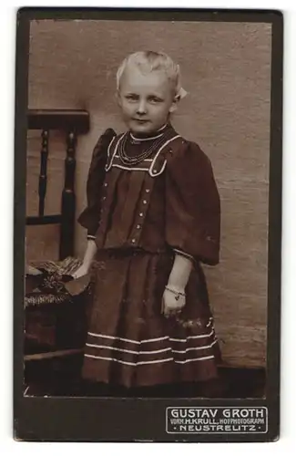 Fotografie Gustav Groth, Neustrelitz, Portrait freches blondes Mädchen im hübschen Kleid