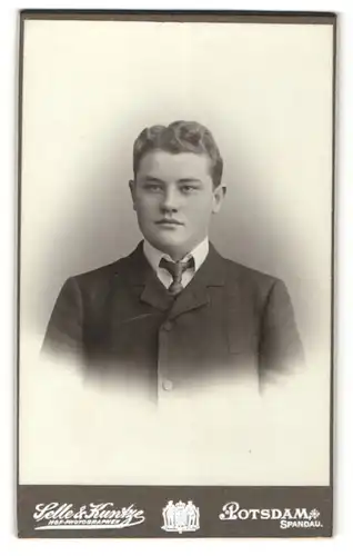 Fotografie Selle & Kuntze, Potsdam, Portrait charmanter junger Mann mit Krawatte im Anzug