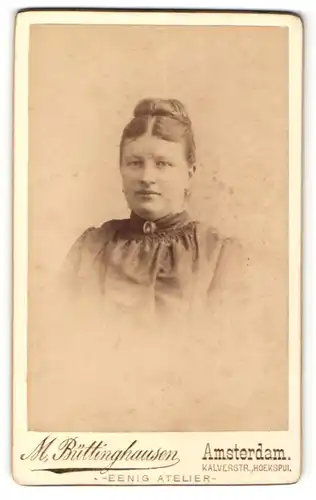 Fotografie M. Büttinghausen, Amsterdam, Portrait charmant lächelnde junge Dame mit hochgestecktem Haar