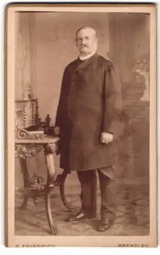 Fotografie G. Friedrich, Prenzlau, Portrait Herr in Anzug mit Mantel