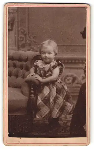 Fotografie Fotograf & Ort unbekannt, lächelndes kleines Mädchen mit blondem Haar im karierten Kleid