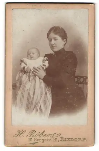 Fotografie H. Böbers, Berlin, hübsche junge Mutter im schwarzen Kleid mit niedlichem Baby