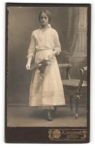 Fotografie A. Jandorf & Co, Berlin, schönes junges Mädchen im bestickten Kleid mit Buch und Blumenstrauss