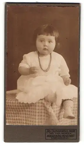 Fotografie Ad. Junghans, Magdeburg-Neustadt, Portrait Kleinkind in Kleidchen