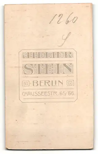 Fotografie Wilhelm Stein, Berlin, Portrait Knabe mit Buch am Tisch