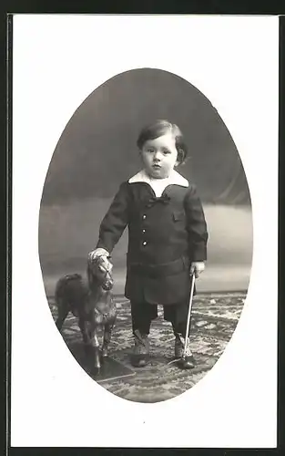Foto-AK Kleinkind in zeitgenöss. Kleidung mit Spielzeugpferd