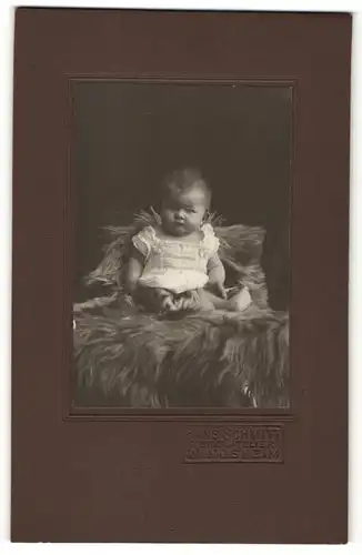 Fotografie Hans Schmitt, Windsheim, Portrait Säugling auf Fell sitzend