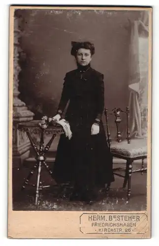 Fotografie Herm. Besteher, Friedrichshagen, dunkelhaariges hübsches Fräulein mit Blumenstrauss im schwarzen Kleid