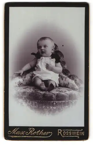 Fotografie Max Rother, Rosswein, zuckersüsses blondes Kleinkind im weissen Kleidchen mit schwarze Schleifen