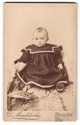 Fotografie D. Mendelsohn, Berlin, zuckersüsses Kleinkind im schwarzen Kleid mit weisser Stickerei