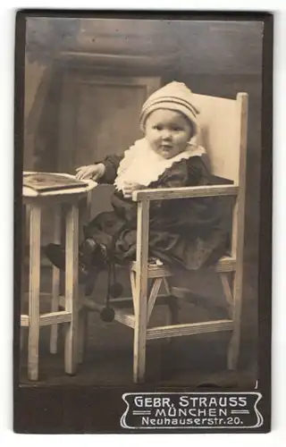 Fotografie Gebr. Strauss, München, Portrait Kleinkind auf Kindersitz