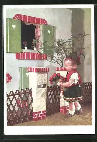 AK Käthe Kruse-Puppe in bayr. Tracht mit Blumenstrauss steht am Fenster