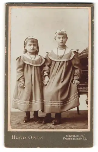 Fotografie Hugo Opitz, Berlin-N, Portrait zwei Schwestern in identischen Kleidern