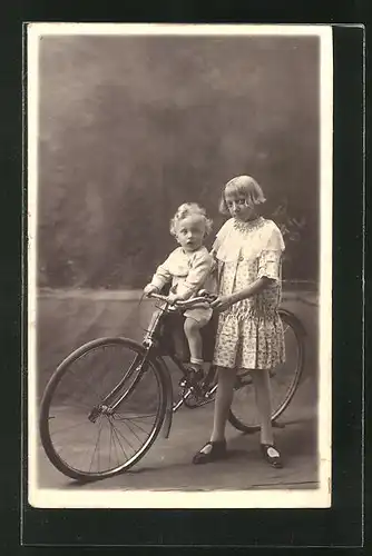 Foto-AK Mädchen mit Fahrrad und Kleinkind auf dem Kindersitz