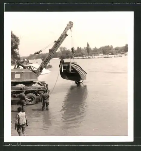 Fotografie Bundeswehr, Kran hebt Sturmboot aus dem Wasser