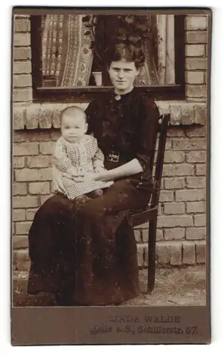 Fotografie Linda Walde, Halle / Saale, schöne Mutter mit süssem Baby vor einem Haus sitzend