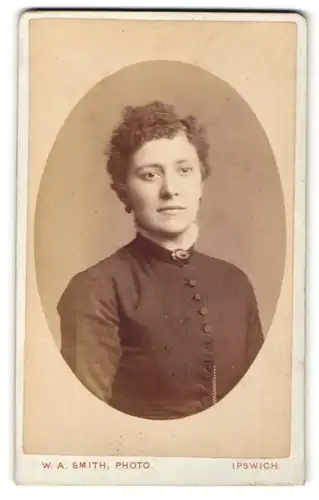 Fotografie W. A. Smith, Ipswich, Portrait charmant blickende junge Dame mit Ohrringen und Brosche am Kragen