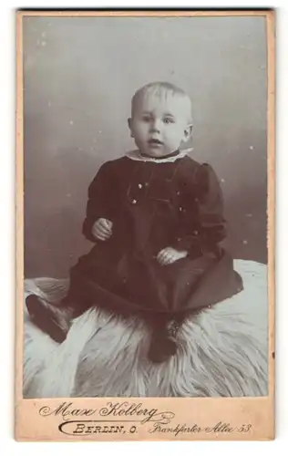 Fotografie Max Kolberg, Berlin, zuckersüsses blondes Kleinkind im schwarzen Kleid und Stiefelchen