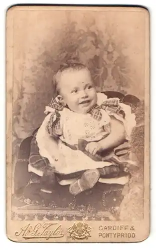 Fotografie Ad. G. Taylor, Cardiff, lachendes süsses Baby im tollen Kleid mit karierten Schleifen