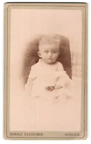 Fotografie Rudolf Fleischer, Schleiz, zuckersüsses blondes Kleinkind mit Spielzeug im weissen Hemdchen
