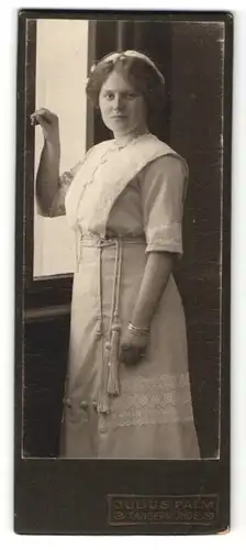 Fotografie Julius Palm, Tangermünde, hübsches Fräulein mit Haarband im aufwendig besticktem Kleid und Kordeln