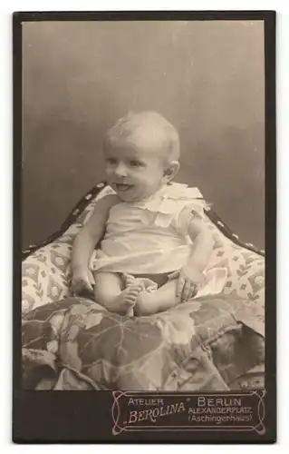 Fotografie Atelier Berolina, Berlin, bezaubernd süss lachendes Kleinkind mit blondem Haar im weissen Hemdchem mit Schleife