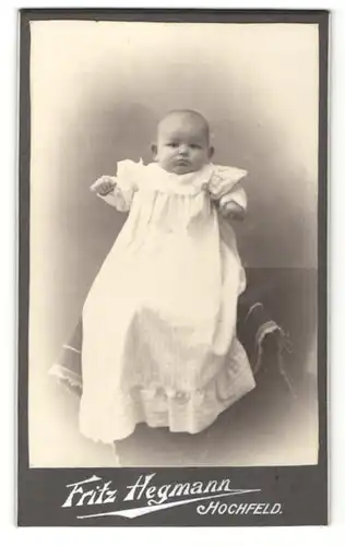 Fotografie Fritz Hegmann, Hochfeld, niedliches Baby im Taufkleid