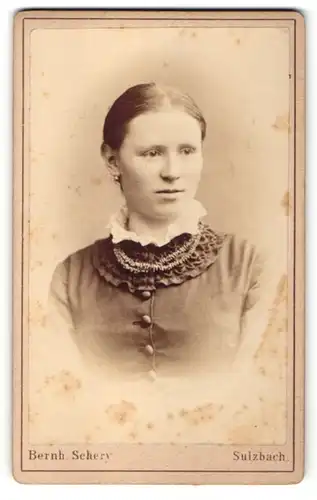 Fotografie Atelier Bernh. Schery, Sulzbach, Frau mit zurückgekämmten Haaren und dunkler Bluse mit weissem Kragen