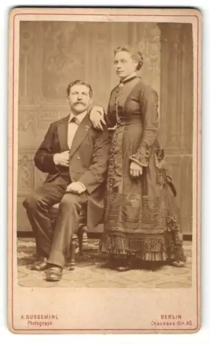 Fotografie A. Sussemihl, Berlin, Mann im Anzug sitzend neben Frau im Kleid stehend