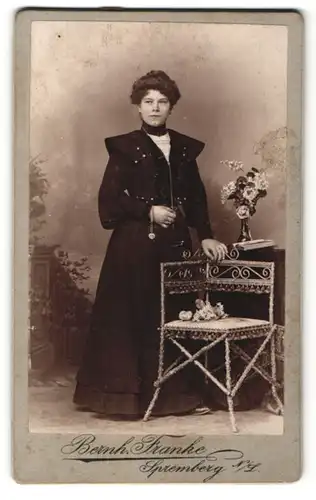 Fotografie Bernh. Franke, Spremberg, Junge Frau im Kleid an Stuhl stehend