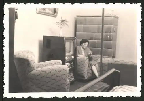 Fotografie TV-Gerät, Hausfrau neben Fersehapparat sitzend