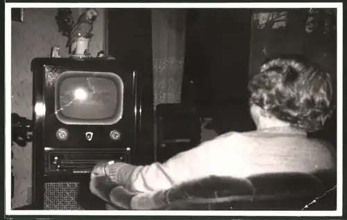 Fotografie TV-Gerät, Hausfrau vor Ferseh-Apparat sitzend