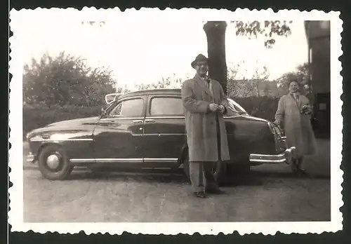 Fotografie Auto, stolzer Fahrer neben Limousine mit Sonnenblende