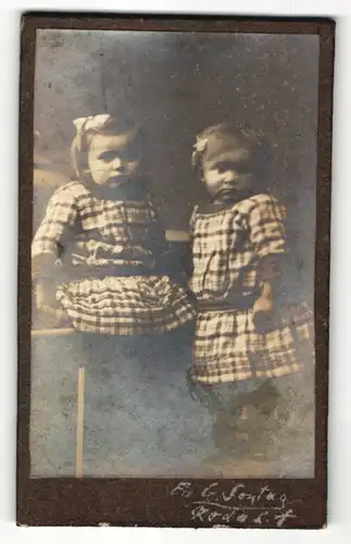Fotografie E. Sontag, Ort unbekannt, Portrait zweier kleiner Mädchen in karierten Kleidern