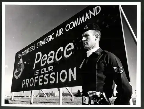 Fotografie USIS, Ansicht Offutt Air Force Base / Nebraska, Sgt. in Uniform neben Schild: Peace is our profession