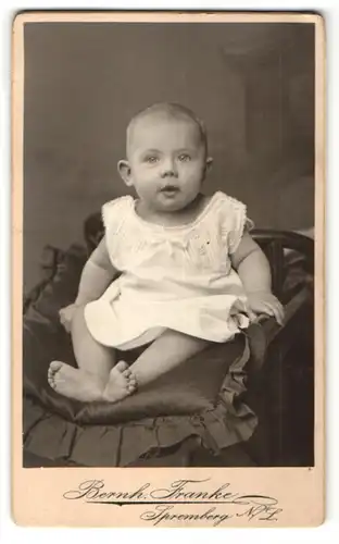 Fotografie Bernh. Franke, Spremberg, zuckersüsses Baby mit grossen Augen im weissen Kleidchen