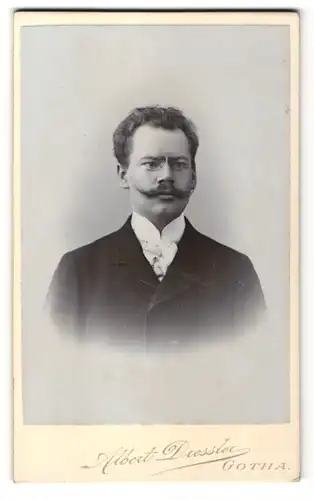 Fotografie Albert Dressler, Gotha, Portrait charmanter junger Mann in gepunkteter Krawatte mit Zwicker und Schnauzer