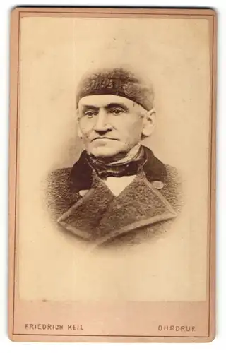 Fotografie Friedrich Keil, Ohrdruf, Portrait betagter älterer Herr mit Mütze und Halstuch